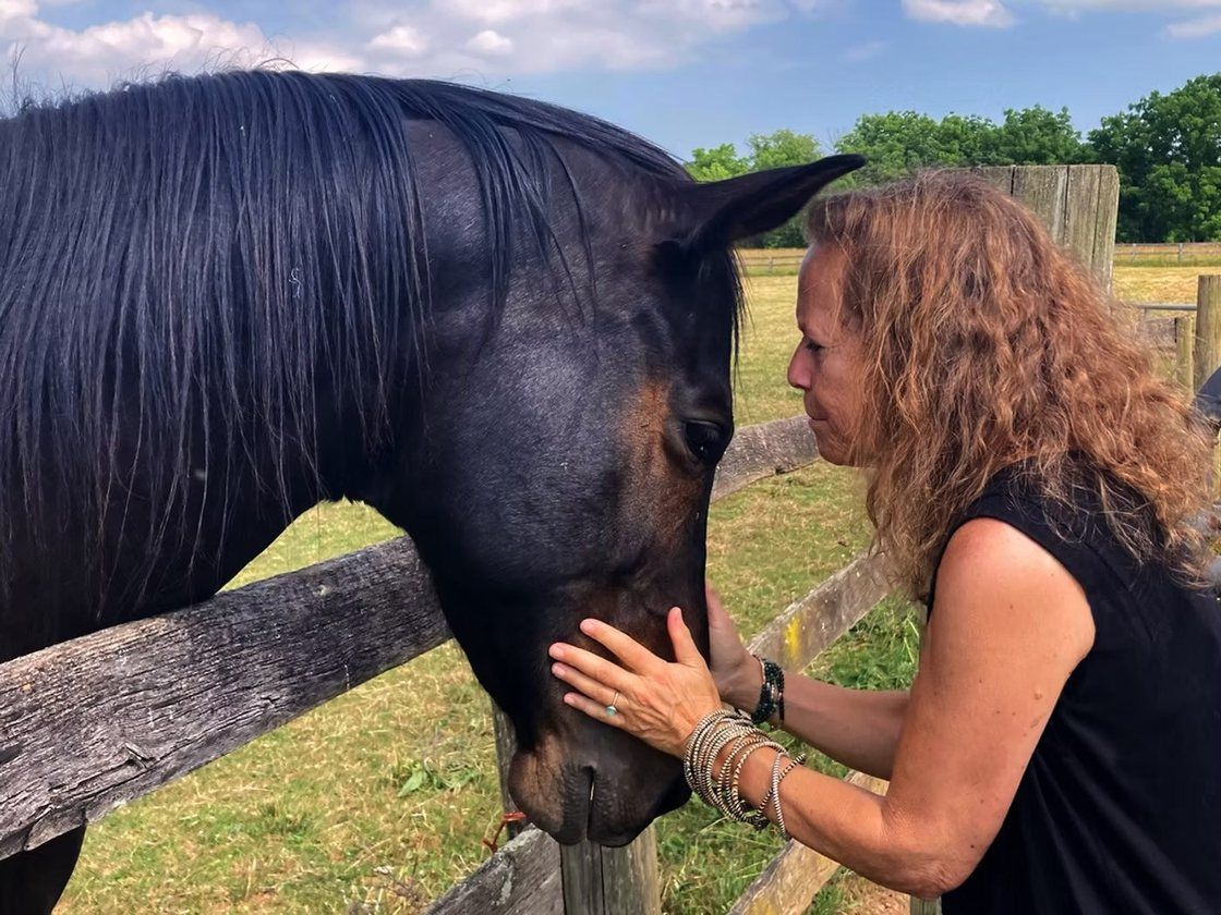 Donna Sue Rosenthal with a horse at a fence